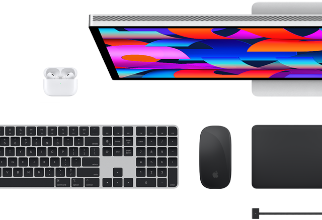 Bovenaanzicht van een aantal Mac-accessoires: Studio Display, Magic Keyboard, Magic Mouse, Magic Trackpad, AirPods en MagSafe-oplaadkabel