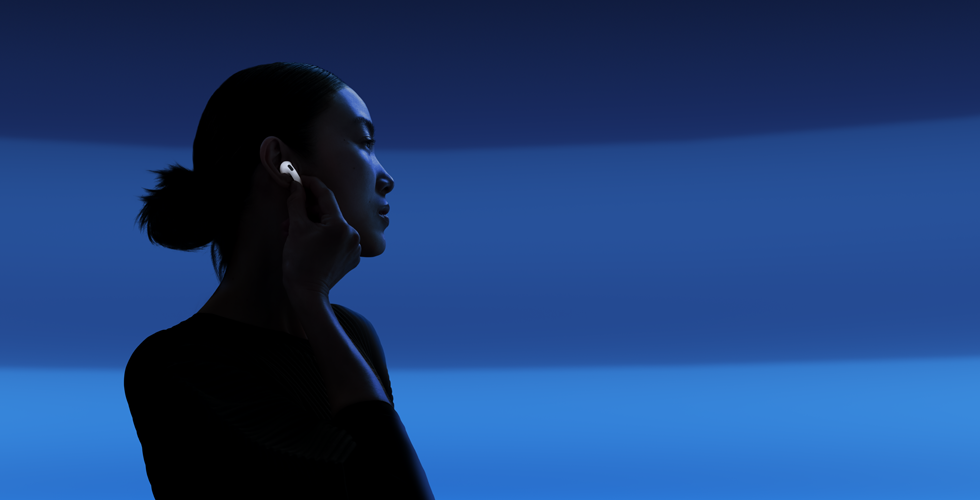 A person with their thumb and index finger holding the stem of their AirPods 5 to change listening modes
