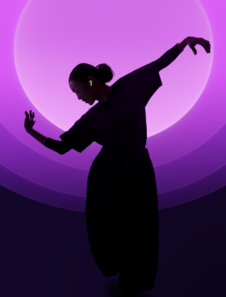 A person dancing while wearing AirPods 5, multicolour background