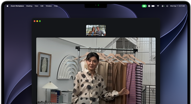 A video call on a MacBook Pro where a woman shows fabrics to two people on the call, with Centre Stage keeping her centred in the frame as she moves around