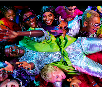 Kleurrijk scherm op een MacBook Pro van iemand die crowdsurft op een feest, ter illustratie van het levendige Liquid Retina XDR-display